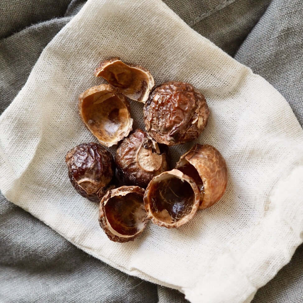 Billede af sæbebær fra Care by Nature på ubleget bomuldspose fotograferet oppefra på beige hørstof